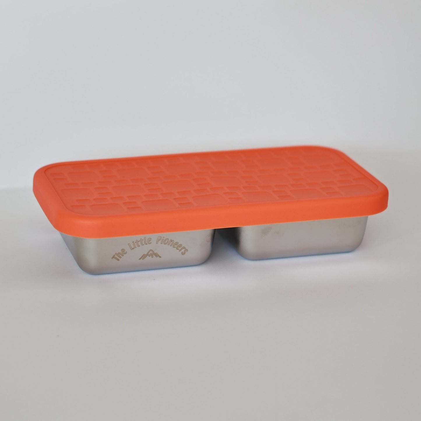 Rectangular metal container with an orange lid on a light gray background