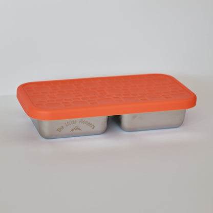 Rectangular metal container with an orange lid on a light gray background